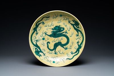Un plat en porcelaine de Chine famille verte à décor de dragons sur fond jaune, probablement Qianlong