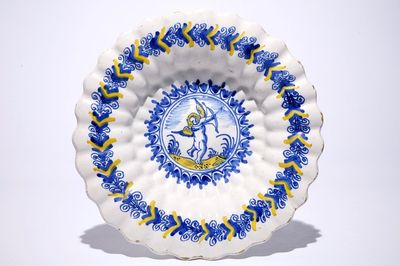 Un plat polylobé en faïence de Delft à décor d'un putto en bleu et jaune, Haarlem, 17ème