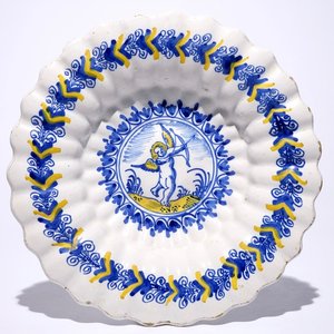 Un plat polylobé en faïence de Delft à décor d'un putto en bleu et jaune, Haarlem, 17ème — photo 1