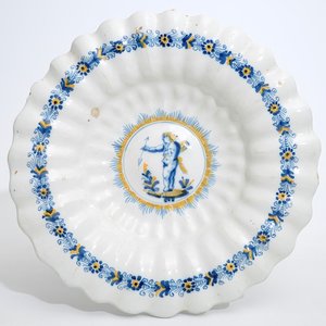 Un plat polylobé en faïence de Delft à décor d'un putto en bleu et jaune, Haarlem, 17ème — photo 1