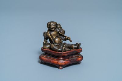 Un poids à rouleau figurant Liu Hai en bronze sur socle en bois, Chine, Ming