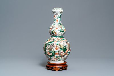 Un vase de forme double gourde en porcelaine de Chine famille verte sur socle en bois, 19/20ème
