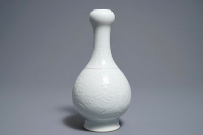 Un vase en porcelaine blanc de Chine à décor incisé de dragons, marque de Qianlong, 19/20ème