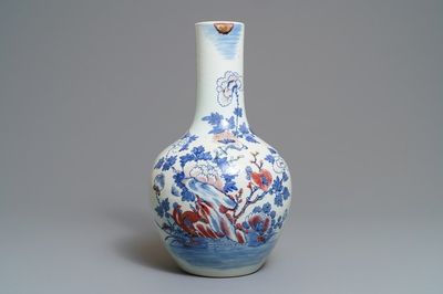 Un vase en porcelaine de Chine bleu, blanc et rouge à décor de coqs, 19ème