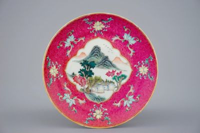 Une assiette en porcelaine de Chine à décor d'un paysage sur fond rouge rubis, 19/20ème