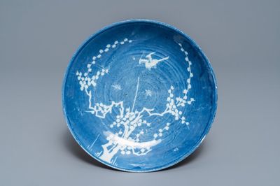 Une assiette en porcelaine de Chine à décor inverse en blanc et bleu, époque Transition