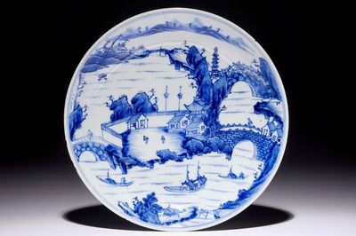 Une assiette en porcelaine de Chine bleu et blanc à décor de paysages, Kangxi, vers 1660
