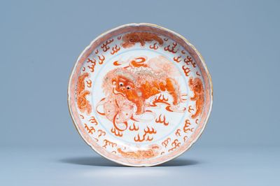 Une assiette en porcelaine de Chine en bleu, blanc et rouge de fer à décor de lions bouddhistes, marque de Qianlong, 19ème