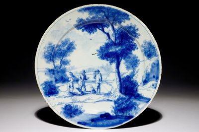 Une assiette raffinée en faïence de Delft bleu et blanc figurant à décor de personnages dans un paysage, début du 18ème