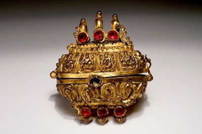 Une boîte d'amulette en bronze doré incrusté de verre colorié, Inde, 18ème