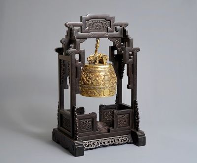Une cloche en bronze doré dans son cadre de suspension en bois de zitan, marque de Qianlong, 18/19th C.