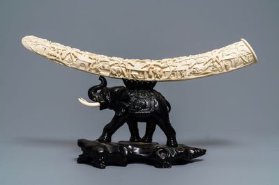 Une défense d'ivoire sculptée sur socle en bois en forme d'éléphant, Chine, vers 1900