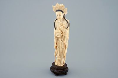 Une figure de Guanyin en ivoire sculpté sur socle en bois, début du 20ème