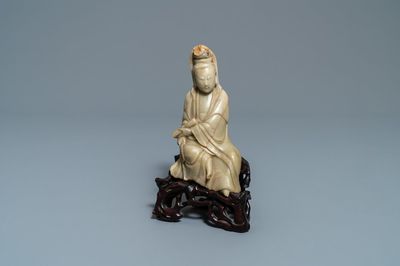 Une figure de Guanyin en pierre à savon sur socle en bois sculpté, Chine, 19ème