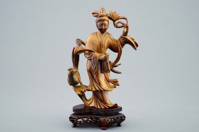 Une figure de Guanyin en pierre oeil de tigre sculptée sur socle en bois, 19/20ème