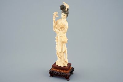 Une figure d'une beauté aux fleurs en ivoire sculpté sur socle en bois, début du 20ème