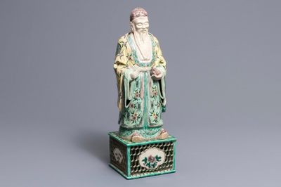 Une grande figure d'un immortel en biscuit émaillé vert sur socle, Kangxi