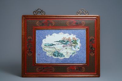 Une grande plaque en porcelaine de Chine famille rose dans un cadre en bois laqué, 19ème