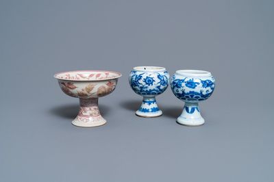 Une paire de bols sur piedouche en porcelaine de Chine en bleu et blanc et un en rouge de cuivre, 19/20ème