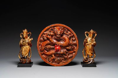 Une paire de figures de gardiens en bois laqué doré et une plaque ronde à décor de dragon, Chine, 19ème