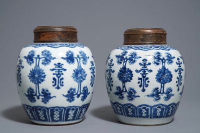 Une paire de pots en porcelaine de Chine bleu et blanc aux couvercles en bois, 18/19ème