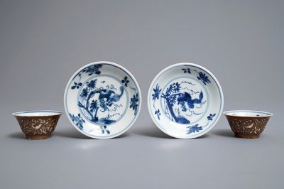 Une paire de tasses et soucoupes en porcelaine de Chine bleu et blanc à décor gravé sur fond brun capucin, Kangxi