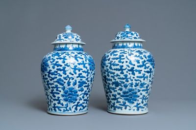 Une paire de vases couverts en porcelaine de Chine en bleu et blanc à décor de rinceaux de pivoines, Kangxi