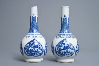 Une paire de vases de forme bouteille en porcelaine de Chine bleu et blanc, marque de Kangxi, 19/20ème