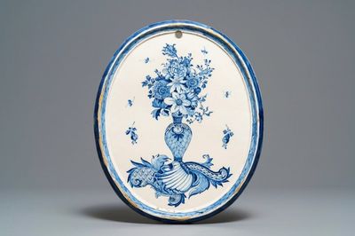 Une plaque de forme ovale en faïence de Delft bleu et blanc à décor d'un vase fleuri, 18ème