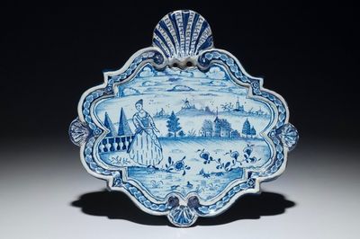Une plaque en faïence de Delft bleu et blanc à décor d'une femme dans un paysage, 18ème