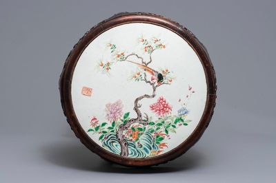Une plaque en porcelaine de Chine famille rose dans un socle en bois, 19/20ème