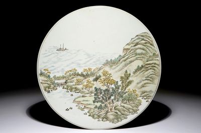 Une plaque ronde en porcelaine de Chine polychrome à décor d'un paysage, 19/20ème