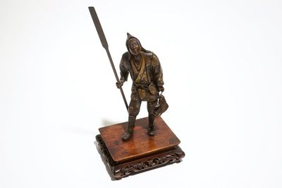 Une statuette d'un pêcheur en bronze, sur socle en bois, marqué Miyao, Japon