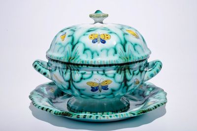 Une terrine couverte sur son support en faïence de Bruxelles à décor "Aux papillons", 18ème