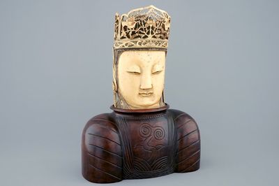 Une tête de Bouddha en ivoire sculpté sur socle en bois, Chine, 19ème