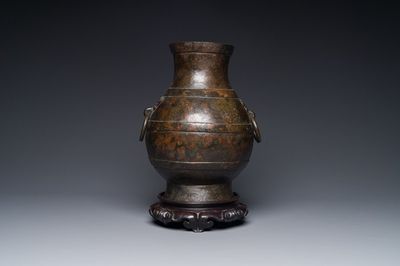 Vase de forme 'hu' en bronze aux anses en forme de taotie dans le style de Han sur socle en bois, Chine, Ming