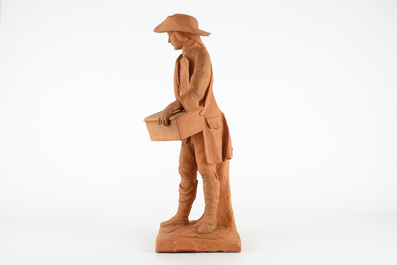 A tall terracotta figure of a hurdy-gurdy player, early 19th C.