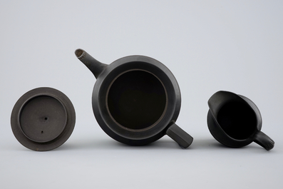 A Wedgwood black basalt teapot and cream jug, 19th C.