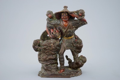 A Japanese terracotta okimono of a fruit vendor with monkeys, Edo/Meiji, 18/19th C.