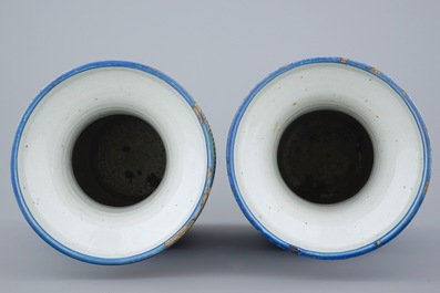 A pair of Chinese blue ground famille rose vases with flowers, 19th C.