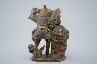 A Japanese terracotta okimono of a fruit vendor with monkeys, Edo/Meiji, 18/19th C.