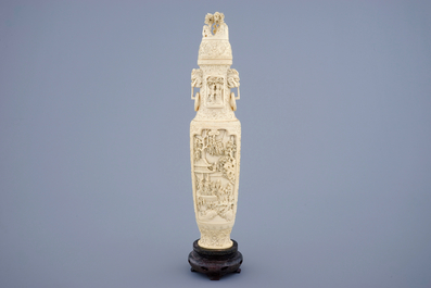 A Chinese carved ivory vase and cover on a wooden base, early 20th C.