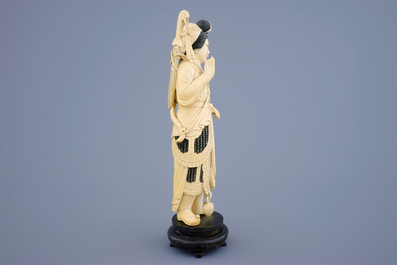 A Chinese carved ivory figure of a female warrior on a wooden base, late 19th C.