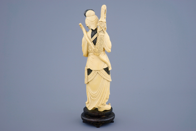 A Chinese carved ivory figure of a female warrior on a wooden base, late 19th C.