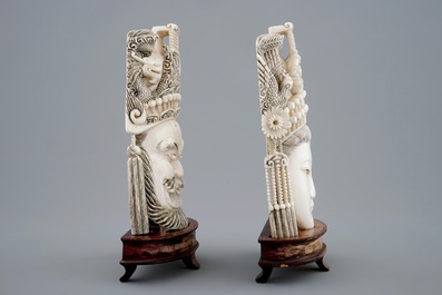 A pair of Chinese carved ivory faces on wooden stands, 19th C.