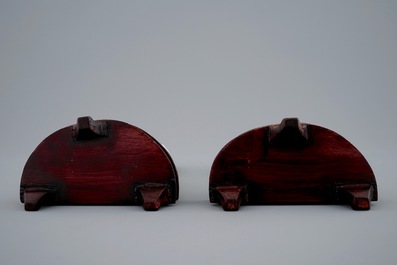 A pair of Chinese carved ivory faces on wooden stands, 19th C.