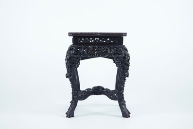 An intricately carved square Chinese wood stand with marble top, 19th C.