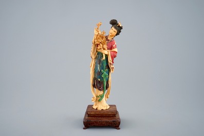 Een polychrome Chinese ivoren figuur van Guanyin op houten sokkel, 19e eeuw