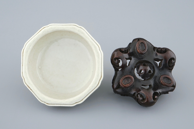 An octagonal Chinese celadon tripod censer on carved wooden base, impressed Qianlong mark, 19th C.