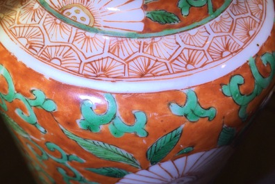 A Chinese famille verte coral-ground rouleau vase with peony scrolls, Kangxi